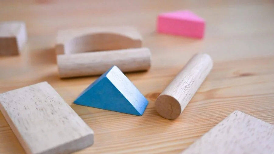 Young child engaged with building blocks on floor, demonstrating age-appropriate play and safety in toy selection