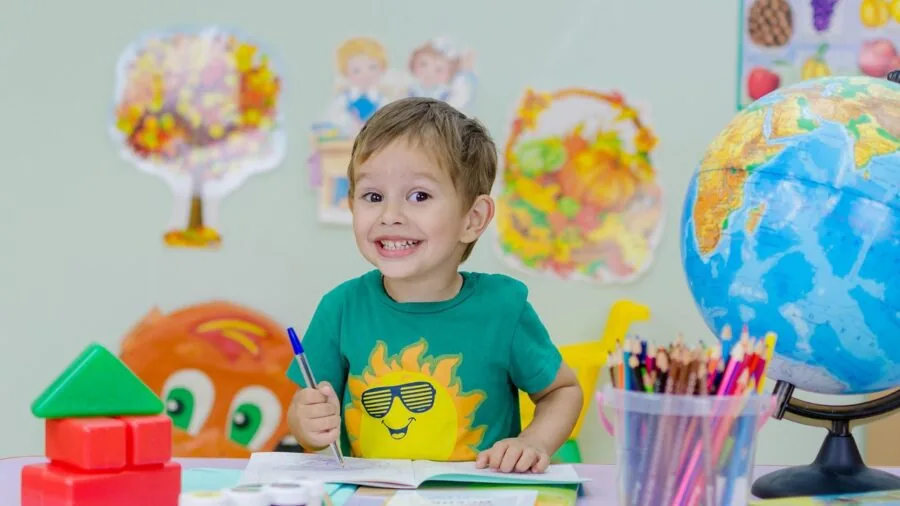 Young child engaged with colorful illustrated learning materials showing real-world objects and concepts