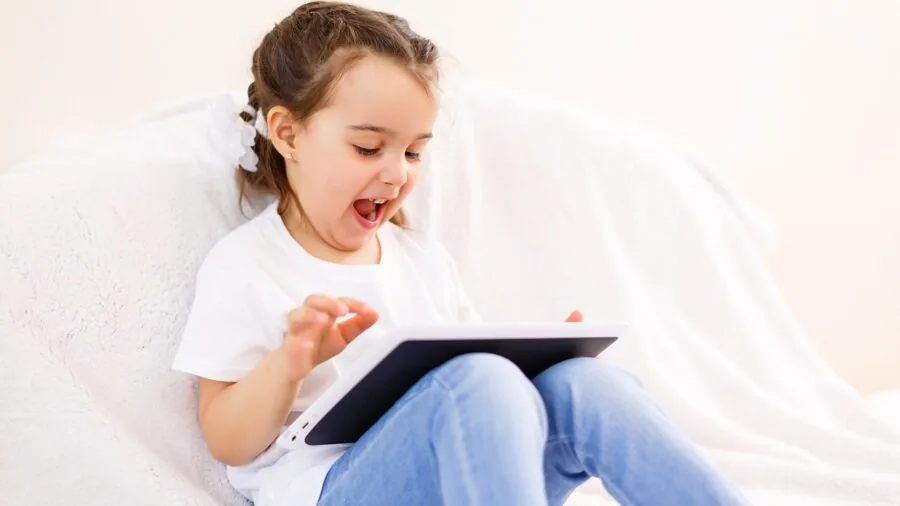 Young child engaged with educational content on tablet in comfortable home setting