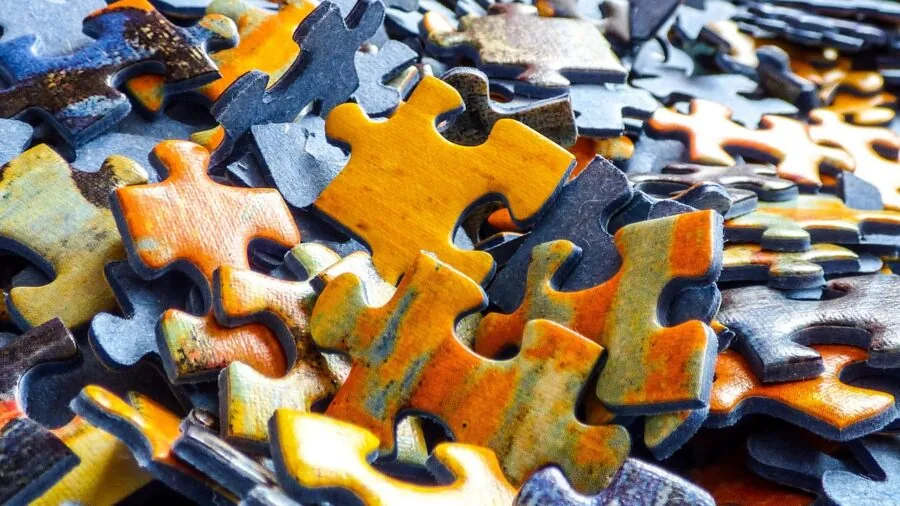 Young child engaged with wooden puzzle pieces at a table, demonstrating safe play and age-appropriate puzzle activity