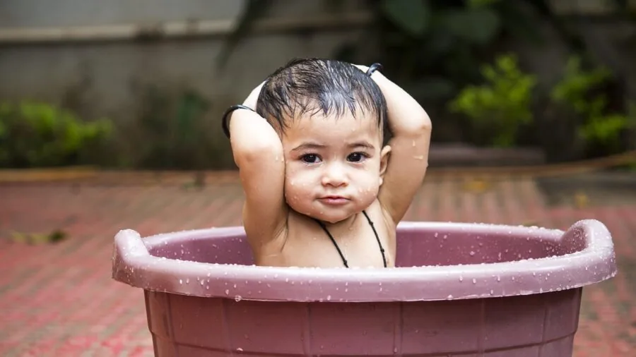 Young child enjoying bubbles in a sunny outdoor garden setting with natural lighting
