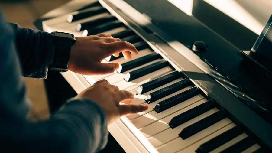 Young child enthusiastically playing on a sturdy keyboard instrument in a home setting