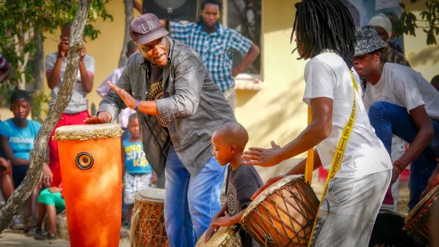 Young child enthusiastically playing with a musical instrument outdoors in natural daylight