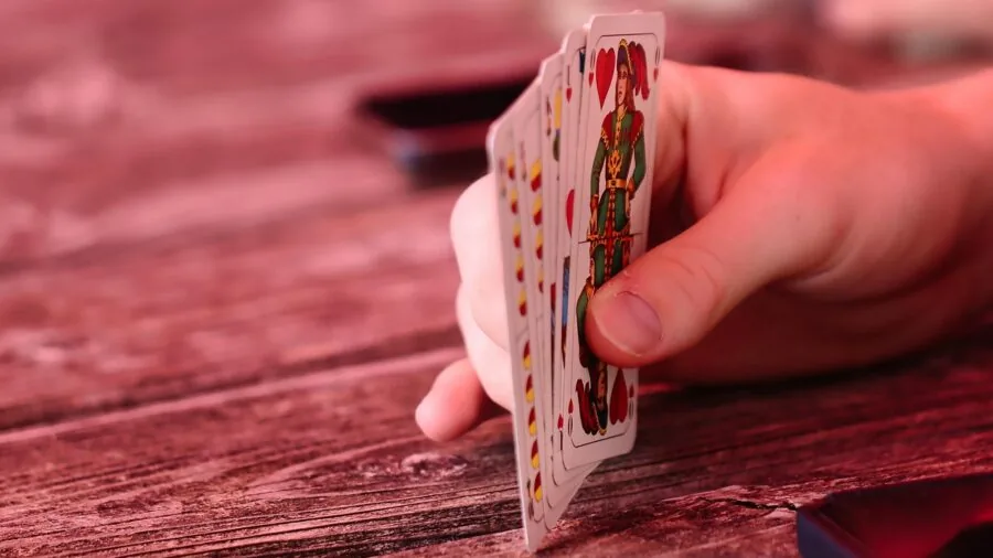 Young child examining damaged game cards during playtime, showing wear and tear on cardboard pieces