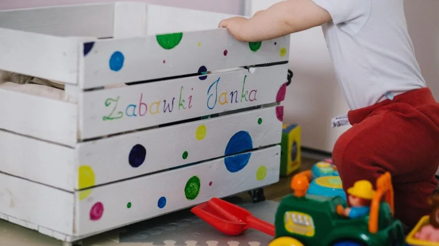 Young child examining wooden toy blocks during playtime, demonstrating safe toy interaction and durability testing