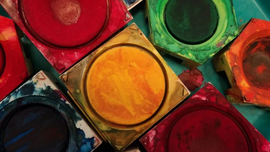 Young child experimenting with mixing watercolors and paint on paper during art activity