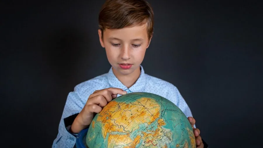 Young child exploring and learning geography with a colorful globe at home