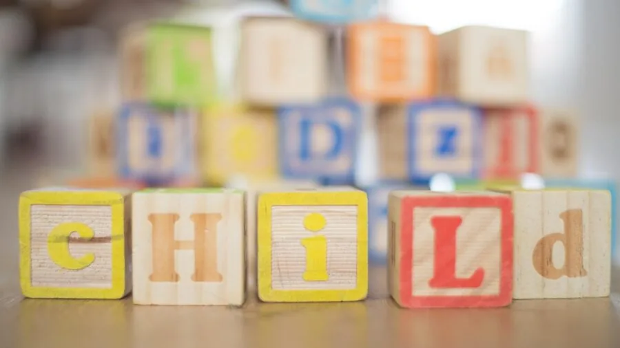 Young child focused on playing with simple wooden blocks during independent play time