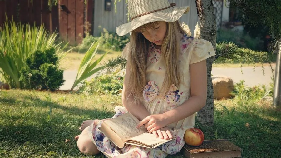 Young child focused on reading instructions while doing a craft activity at home