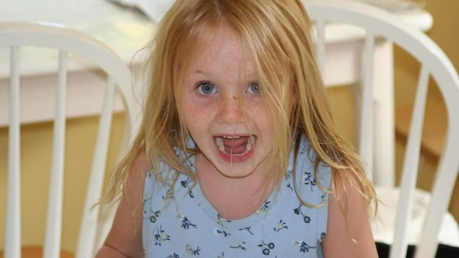 Young child looking confused while holding a toy, struggling to understand how to use it