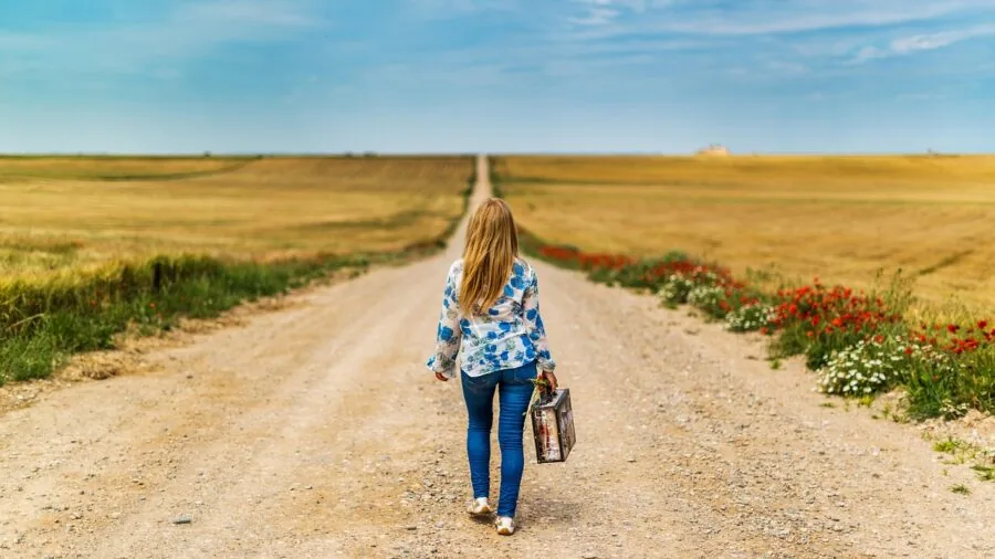 Young child organizing colorful items into a durable suitcase for a family trip