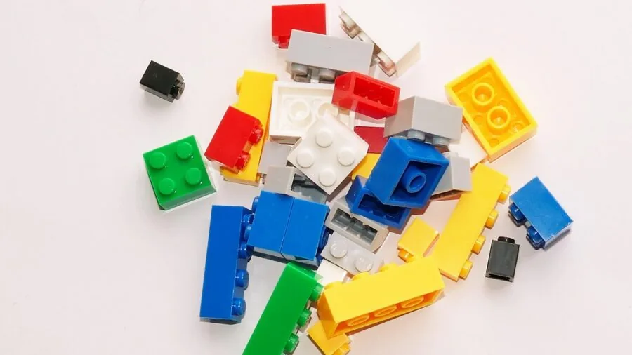 Young child playing with colorful magnetic building blocks on floor, demonstrating durability and safety