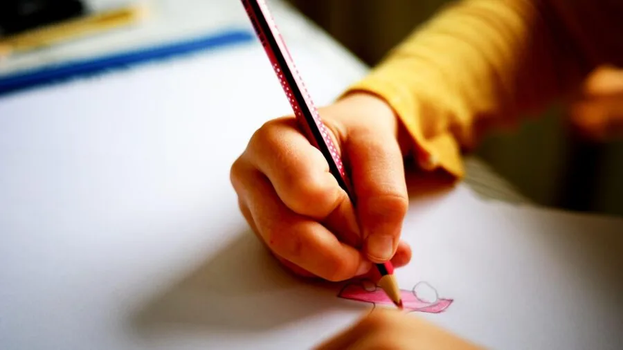Young child reading colorful instruction manual with focused concentration while learning
