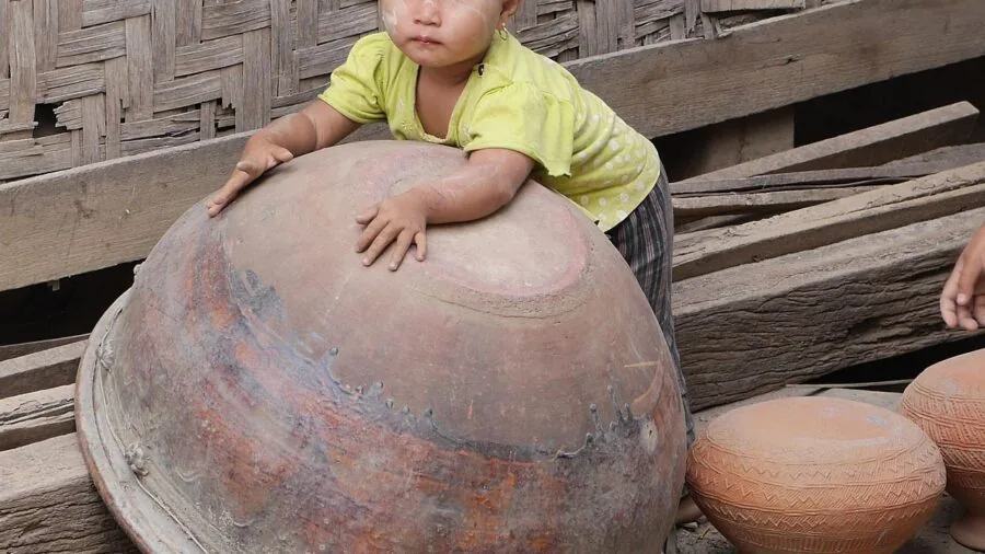 Young child sculpting colorful clay with various modeling tools on a wooden table