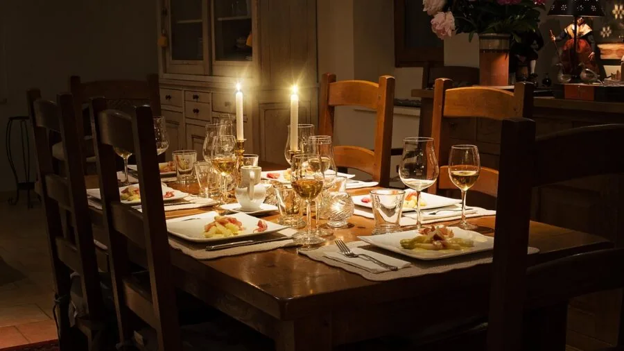 Young child seated at dining table eating meal with family, demonstrating proper chair height alignment