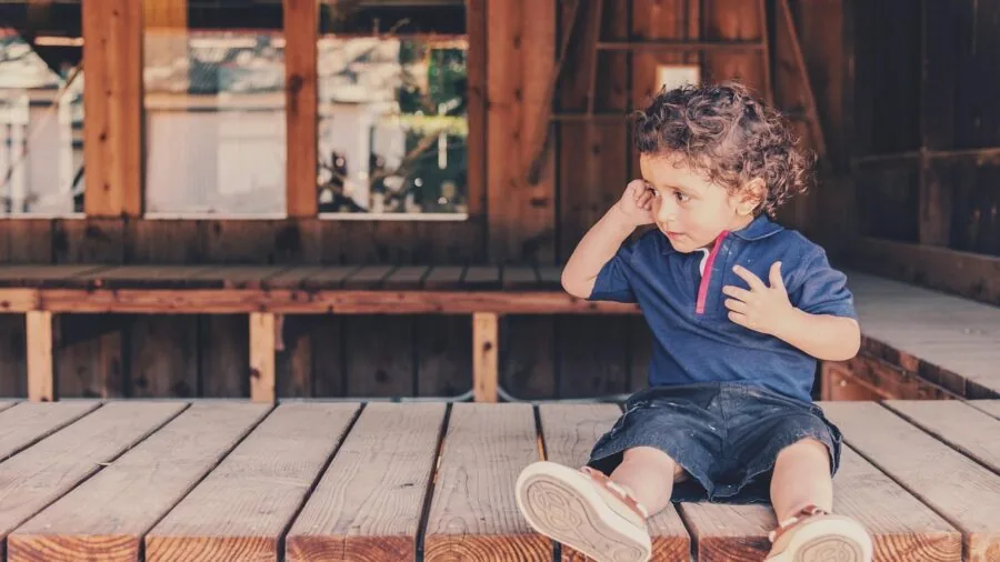Young child sitting confidently on stable chair demonstrating safe, secure seating posture
