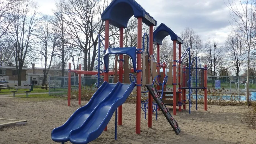 Young child sliding down colorful playground slide on sunny day at park