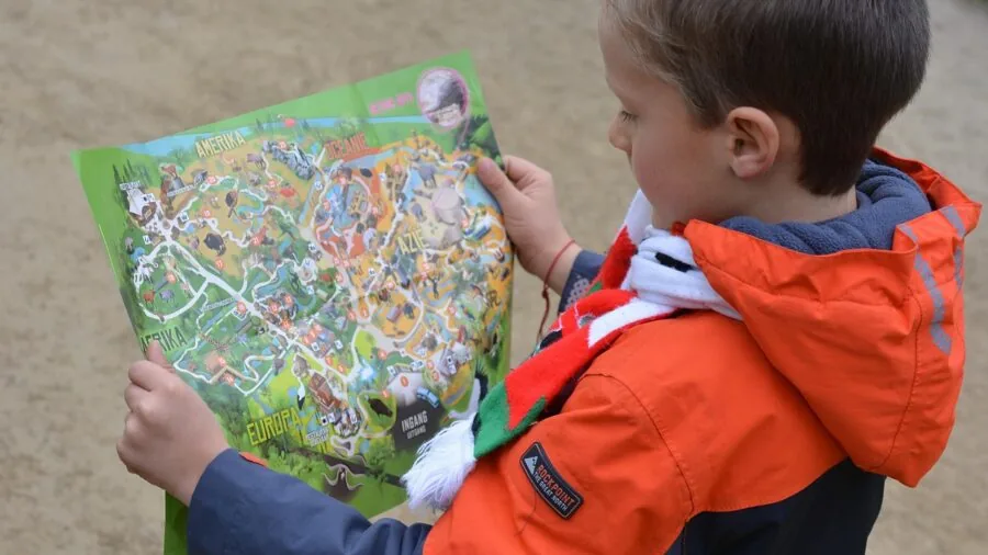 Young child studying a globe with parent, learning geography through interactive exploration