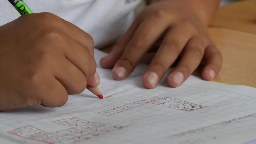 Young child studying with flashcards at a desk, focused on active recall learning practice