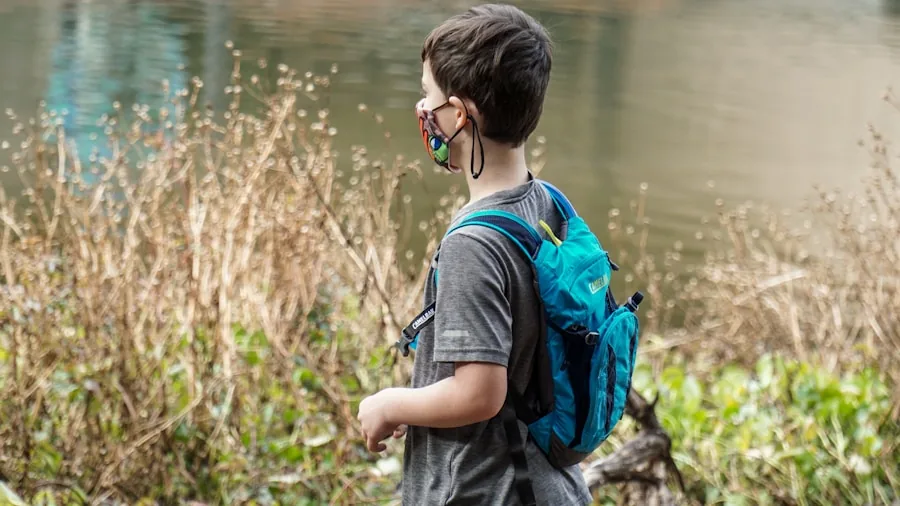 Young child wearing a backpack while exploring outdoors on a nature path
