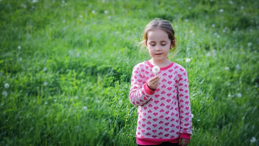 Young child wearing an oversized sweater, examining the fit and sizing during clothing selection