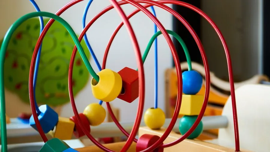 Young children engaged in playing an educational board game together at a table, focusing on developmental learning