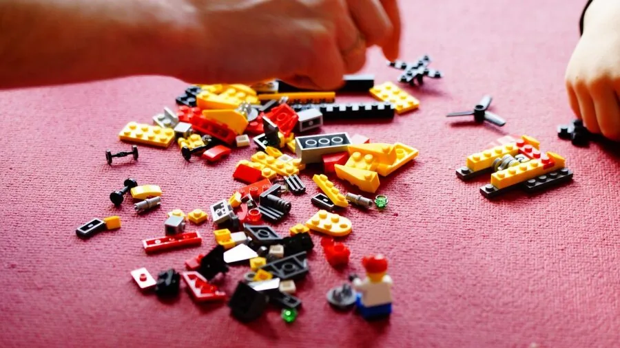 Young child's hands grasping and manipulating colorful wooden blocks during playtime development activity
