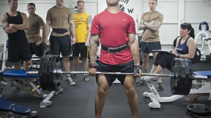 Young lifter performing barbell exercise with focused grip technique during gym training session