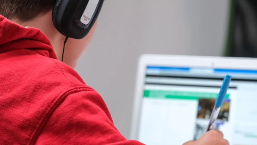 Young student wearing headphones during a remote video call lesson on laptop