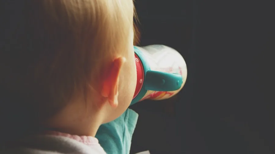 Young toddler learning to drink from cup during mealtime development milestone