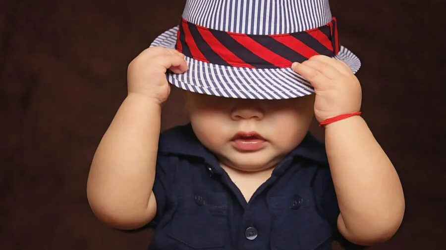 Young toddler trying on different sized clothing to check fit during growth stage
