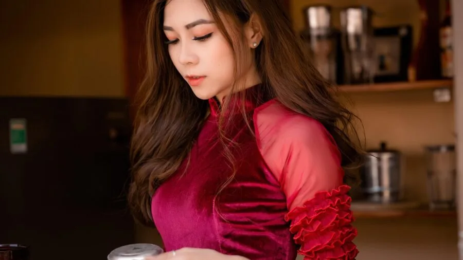 Young woman in fitting room examining formal dress fit and comfort before purchase decision