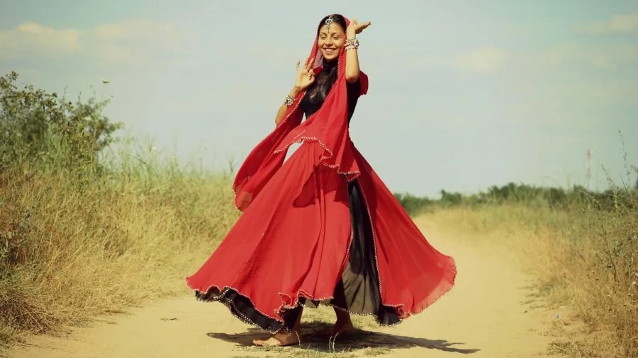 Young woman in midi dress spinning outdoors, demonstrating elegant movement and formal style